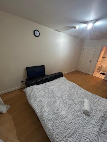 a bedroom with a bed and a clock on the wall at Lovely 1 bedroom apartment in East London in London