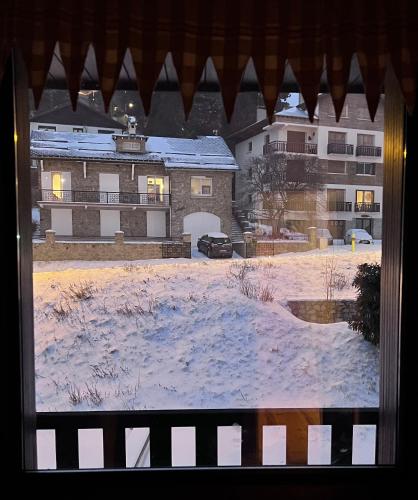 a view of a snow covered yard from a window at Superbe appartement Font Romeu La Pardallera in Font Romeu Odeillo Via