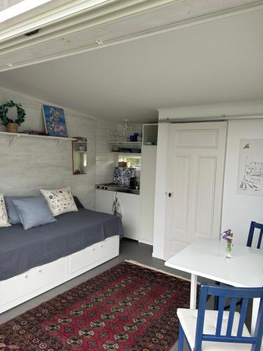 a bedroom with a bed and a table and a white door at Sommarvilan in Vaxholm