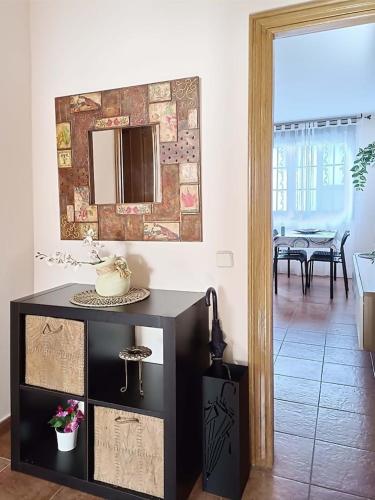 a living room with a table and a mirror at Apartamento ideal en Lastres. in Colunga