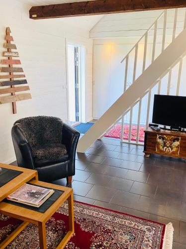 a living room with a chair and a tv at Slamrekullen - Ullared in Ullared