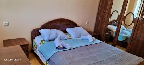 - une chambre dotée d'un lit avec des draps bleus et un miroir dans l'établissement Rita Gujejiani Guesthouse, 