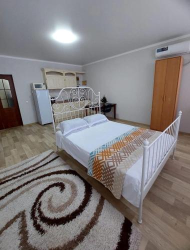 1 dormitorio con cama blanca y alfombra en Абажур, en Aktobe