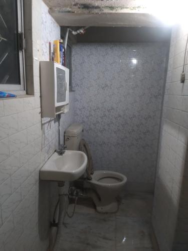 Baño pequeño con aseo y lavamanos en MODI en Calcuta