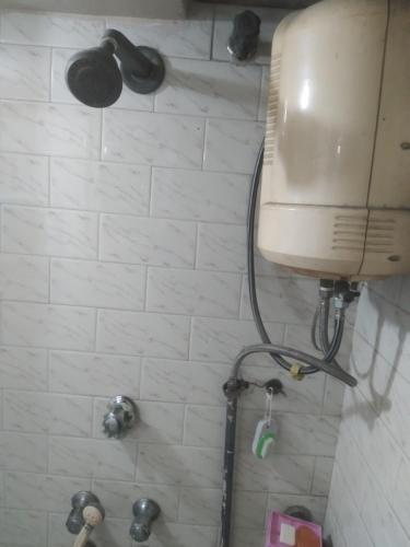 a bathroom with a shower with a tank at MODI in Kolkata