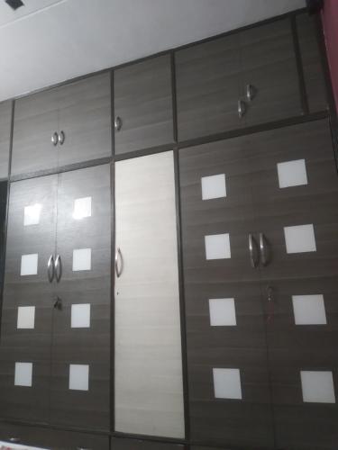 a closet with brown doors and a mirror at MODI in Kolkata