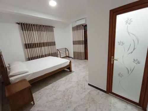 een slaapkamer met een bed naast een deur bij Sara Appartments in Colombo