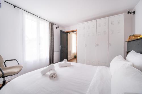 - une chambre blanche avec un grand lit blanc et une chaise dans l'établissement L'Éclat de Label Pierre, à Combs-la-Ville