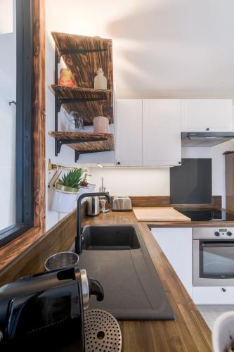 une cuisine avec des armoires blanches et un évier dans l'établissement L'Éclat de Label Pierre, à Combs-la-Ville