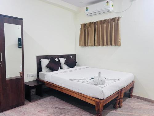 Una cama o camas en una habitación de Hotel Madiwala Grand