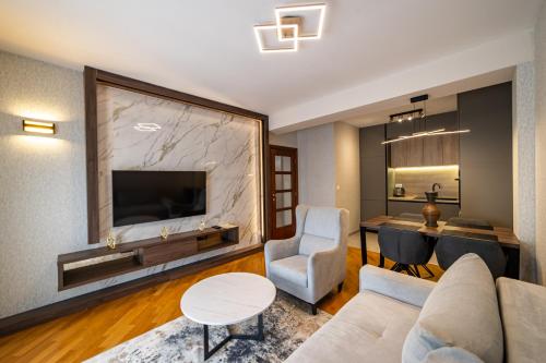 een woonkamer met een bank en een tv bij Apartments 28 in Podgorica