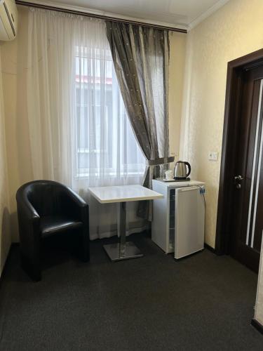 une chambre avec une table, une chaise et une fenêtre dans l'établissement Колібрі, à Reni