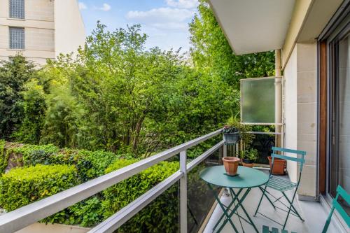 - un balcon avec une table, des chaises et des arbres dans l'établissement Appartement Arazzo - Welkeys, à Versailles