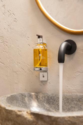 a soap dispenser on a wall next to a sink at Athens Top Penthouse Apartment With Spa 5' to Metro in Athens