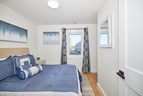 um quarto com uma cama azul e uma janela em 3 Bedroom - Walk to the Falls em Cataratas do Niágara