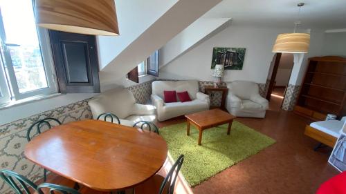 sala de estar con mesa y sofá en Apartamentos Turisticos Queluz, en Queluz