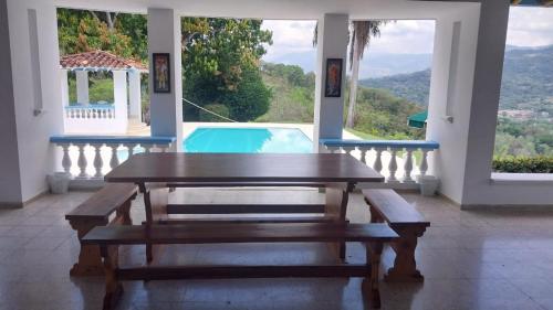una sala da pranzo con tavolo e piscina di Finca Villa Maria a La Pintada