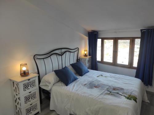 um quarto com uma cama grande e almofadas azuis em La Vía Verde em Jérica