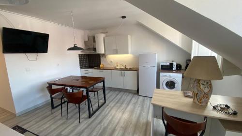 a kitchen and dining room with a table and chairs at Apartamentos Turisticos Queluz in Queluz