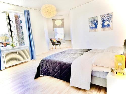 a white bedroom with a bed and a chair at aday - 4 bedrooms holiday apartment in Bronderslev in Brønderslev