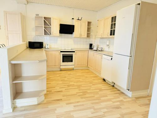 a kitchen with white appliances and wooden floors at aday - 4 bedrooms holiday apartment in Bronderslev in Brønderslev