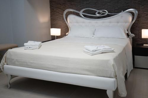 Una cama blanca con dos toallas en una habitación en iitana Luxury Apartment - Catania Fronte Mare en Catania