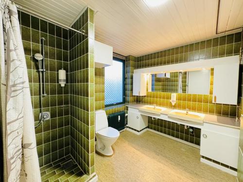a bathroom with a toilet and two sinks and a mirror at aday - 4 bedrooms holiday apartment in Bronderslev in Brønderslev