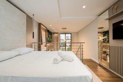 um quarto com uma cama branca e uma varanda em Apto confortável e completo em prédio novo JPR211 em Florianópolis