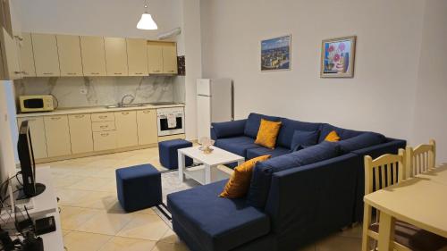 ティラナにあるTirana Bosco's Apartamentの青いソファとキッチンのあるリビングルーム