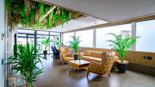 a lobby with a couch and chairs and plants at Stile Suite Marine Hotel in Antalya
