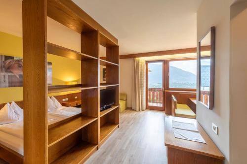 um quarto com duas camas e uma grande janela em Andreas Hofer em Scena