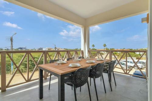 a table and chairs on a balcony with a view at Belnem Breeze Kas di Mars with Communal Pool in Kralendijk