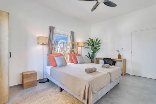 a bedroom with a large bed with orange pillows at Belnem Breeze Kas di Mars with Communal Pool in Kralendijk