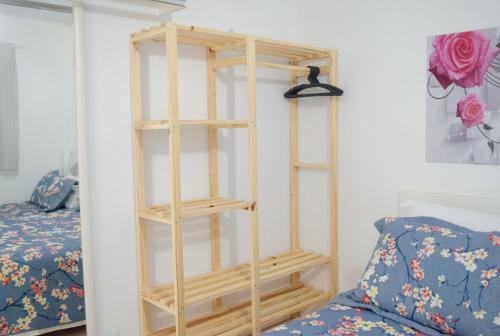 a wooden shelf in a room next to a bed at POUSADA RECANTO SÃO JORGE in Águas de Lindóia