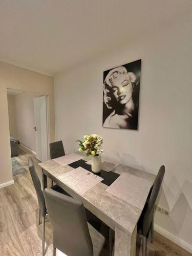 a dining room table with chairs and a vase of flowers at 5 Personen Apartment im Zentrum in Berlin