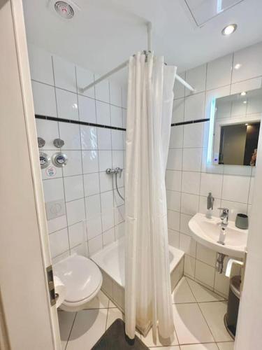 a white bathroom with a toilet and a sink at 5 Personen Apartment im Zentrum in Berlin