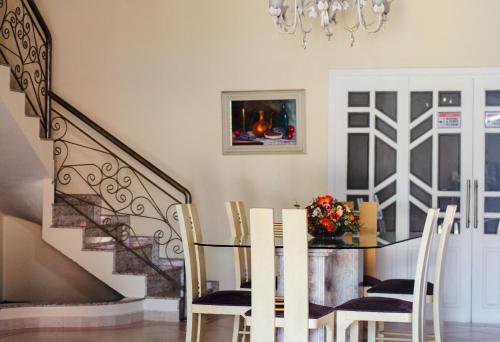 a dining room with a table and chairs and a chandelier at POUSADA RECANTO SÃO JORGE in Águas de Lindóia