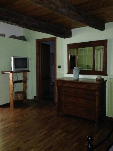 a living room with a tv and a dresser with a microwave at IL Dahù in Pragelato