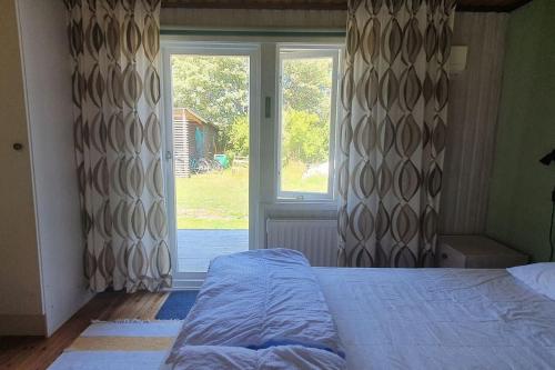 a bedroom with a bed and a large window at Gästhus på Fårös savann. in Fårö