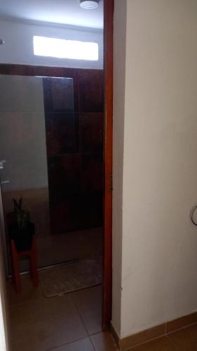 uma porta para um quarto com uma janela e uma cadeira vermelha em Posada San Pedro em Concordia