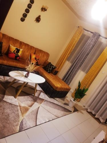 sala de estar con sofá y mesa en T-Tree Paradise Apartments, en Embu