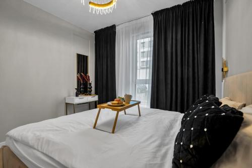 a bedroom with a bed with a table on it at Airport Apartment - Private Terrace & Parking - by Rentujemy in Warsaw
