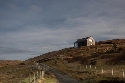 a house sitting on top of a hill at Dark Skye Cottage in Milovaig