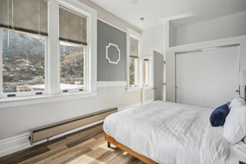 a bedroom with a bed and two windows at THE CARRICK in Bisbee