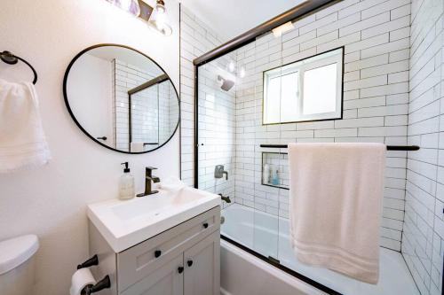 uma casa de banho branca com um lavatório e um espelho em Quiet & Peaceful Home Close to LA/Beaches/Disney em Rosemead