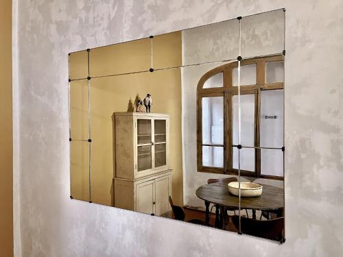 een spiegel aan een muur met een tafel en een raam bij CASA ABEILLE in La Ciotat
