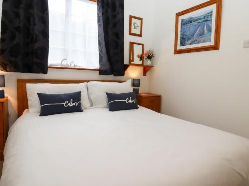 a bedroom with a white bed with blue pillows at The View in Faversham