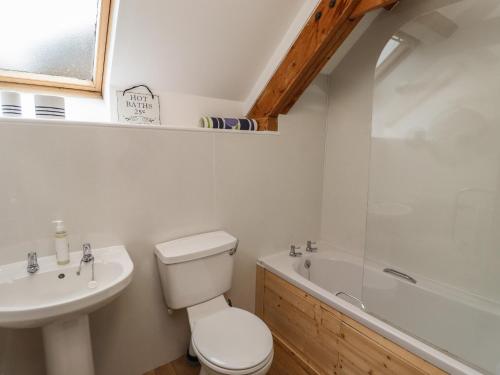 y baño con aseo, lavabo y bañera. en The Boathouse Seahouses en Seahouses