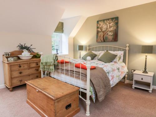 a bedroom with a bed and a dresser at Oakbank in Dumfries