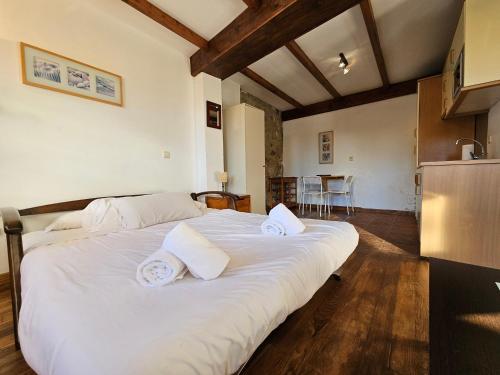 a large white bed in a room with a kitchen at 17A01 -Apartamento Caravia in Caravia